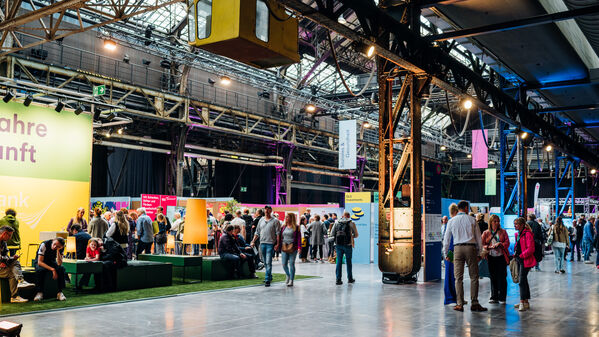 Es handelt sich um eine Indoor-Veranstaltung mit Ständen und Ausstellungen in einer großen Industriehalle.
