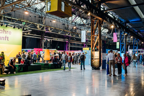 Es handelt sich um eine Indoor-Veranstaltung mit Ständen und Ausstellungen in einer großen Industriehalle.