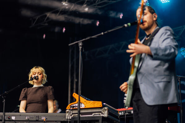 Eine männlich gelesene Person an der Gitarre und Stina Holmquist am Piano auf einer Bühne
